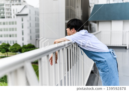 A man gazes out at the city from a rooftop. 139592878