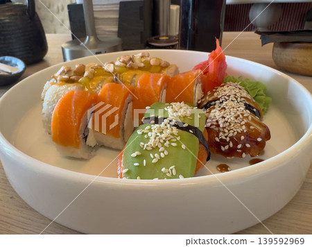 Assorted sushi rolls with salmon, avocado and sesame seeds in a white bowl, close-up of a dish from a Japanese restaurant Assorted sushi rolls with salmon, avocado and sesame seeds in a white bowl, close-up of a dish from a Japanese restaurant 139592969