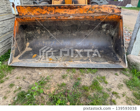 Close-up of dirty front loader bucket, heavy construction equipment attachment used for earthmoving and industrial work 139593038