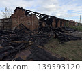 Charred brick ruins of a building with charred debris, the aftermath of a fire and the site of a disaster involving the destruction of a house 139593120