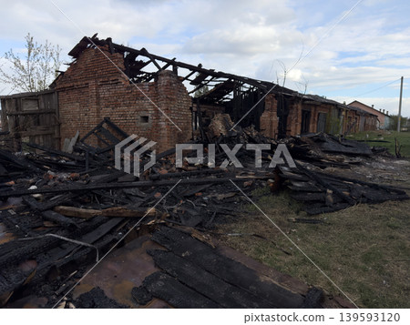 Charred brick ruins of a building with charred debris, the aftermath of a fire and the site of a disaster involving the destruction of a house Charred brick ruins of a building with charred debris, the aftermath of a fire and the site of a disaster involving the destruction of a house 139593120