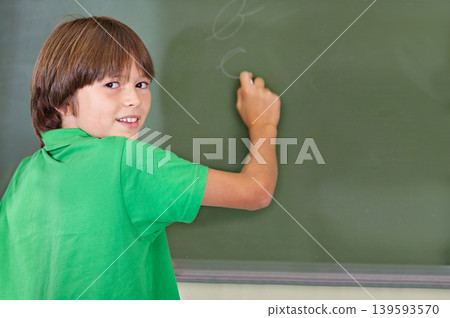 Writing, chalkboard and portrait of kid at school with education and answer for learning. Drawing, knowledge and youth development in study lesson with boy in classroom with chalk and solution 139593570