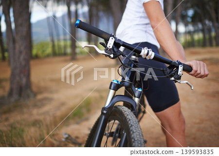 Hands, mountain bike and forest for exercise relax or extreme sport, challenge or journey. Cyclist, gears and off road competition on dirt terrain path for summer performance, training or countryside Hands, mountain bike and forest for exercise relax or extreme sport, challenge or journey. Cyclist, gears and off road competition on dirt terrain path for summer performance, training or countryside 139593835