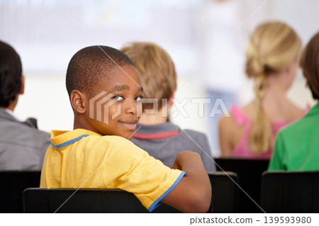 Portrait, black boy or student in classroom for knowledge, education or development for future growth. Scholarship, back to school or happy child in chair for studying, listening or learning at desk Portrait, black boy or student in classroom for knowledge, education or development for future growth. Scholarship, back to school or happy child in chair for studying, listening or learning at desk 139593980
