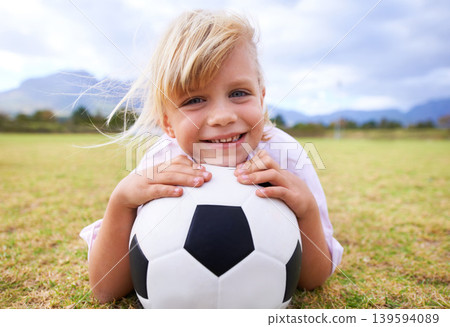 Child, soccer player and ball with portrait, smile and ready for game, field and girl. Outdoor, playful and sport for childhood, happy and athlete for match, alone and outside on football pitch 139594089
