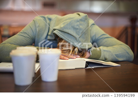 Tired, student or sleeping in library with burnout, stress depression or low energy for deadline. Fatigue, university or exhausted person with books, coffee or head down in nap on table for resting Tired, student or sleeping in library with burnout, stress depression or low energy for deadline. Fatigue, university or exhausted person with books, coffee or head down in nap on table for resting 139594199