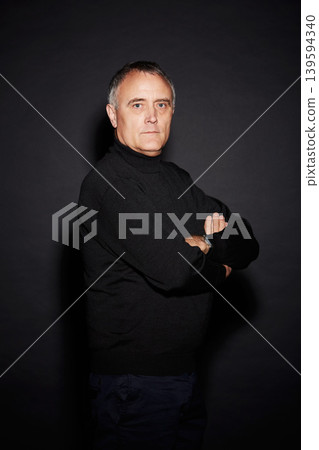 Serious portrait of mature man in studio with arms crossed, confidence and dark fashion style. Pride, relax and senior person isolated on black background with expert knowledge, mystery and wisdom. Serious portrait of mature man in studio with arms crossed, confidence and dark fashion style. Pride, relax and senior person isolated on black background with expert knowledge, mystery and wisdom. 139594340