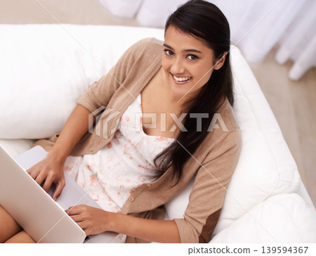 Portrait of woman on couch with laptop, smile and relax with remote work, website and browse in living room. Happy girl on sofa with computer for freelance job, online research and internet in home. Portrait of woman on couch with laptop, smile and relax with remote work, website and browse in living room. Happy girl on sofa with computer for freelance job, online research and internet in home. 139594367