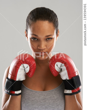 Serious woman, portrait and professional boxer ready for fight or competition against a gray studio background. Female person with boxing gloves for self defense, power or challenge in sports fitness 139594391