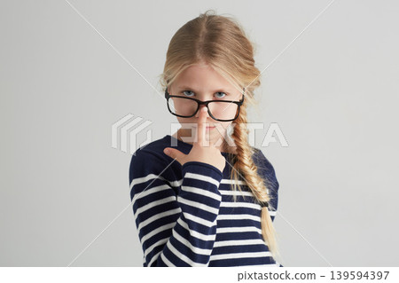 Child, portrait and glasses with serious in mockup, thought and eyewear or nose in studio. Girl, face or geek with blonde hair in fashion with vision, contemplation or smart kid by white background 139594397