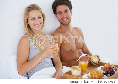 Portrait of happy couple, food and breakfast in bed for morning, wake up or meal together to relax. Man, smile or woman in home eating healthy snack or drinking juice for diet for love in bedroom 139594793