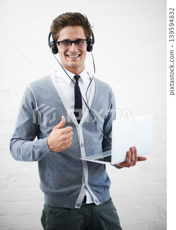 Happy man, portrait and laptop with headphones, thumbs up or winning on a gray studio background. Male person, nerd or geek smile with computer, like emoji or yes sign for good job on mockup space 139594832