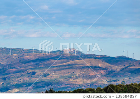 Wind turbines line the hills under a blue sky Wind turbines line the hills under a blue sky 139594857