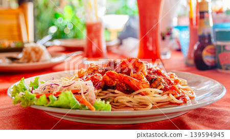 Delicious seafood pasta dish served on a vibrant table at a tropical restaurant Delicious seafood pasta dish served on a vibrant table at a tropical restaurant 139594945