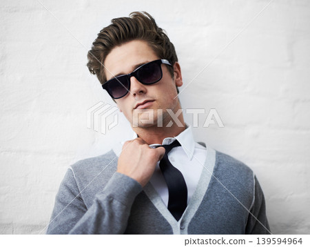 Face, fashion and sunglasses with cool man in studio on white background for attitude or style. Portrait, shades and tie with confident young person or model in casual or trendy clothes outfit Face, fashion and sunglasses with cool man in studio on white background for attitude or style. Portrait, shades and tie with confident young person or model in casual or trendy clothes outfit 139594964