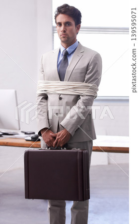 Portrait of businessman in office tied up in rope with depression, control and fear in law firm. Serious attorney, lawyer or legal consultant bound at work, corporate hostage with bag and stress. 139595071