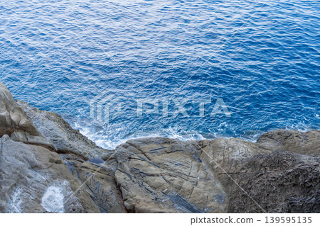 The deep, clear blue seawater and rocky cliffs viewed from above. The deep, clear blue seawater and rocky cliffs viewed from above. 139595135