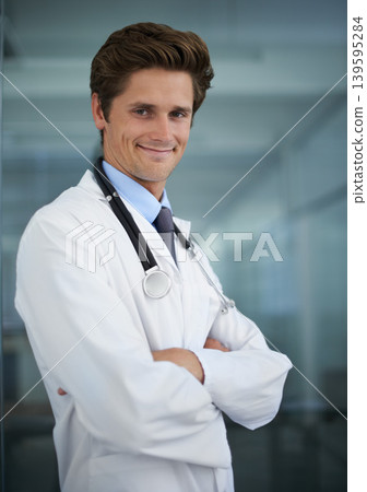Happy, crossed arms and portrait of man doctor with stethoscope for positive, good and confident attitude. Smile, pride and young male healthcare worker in medical office of hospital or clinic. 139595284
