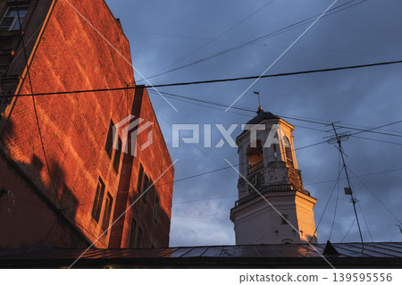 Historic clock tower of Vyborg rises beside a red brick building 139595556