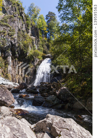 Waterfall Korbu. A secluded waterfall cascades over rugged cliffs Waterfall Korbu. A secluded waterfall cascades over rugged cliffs 139595563