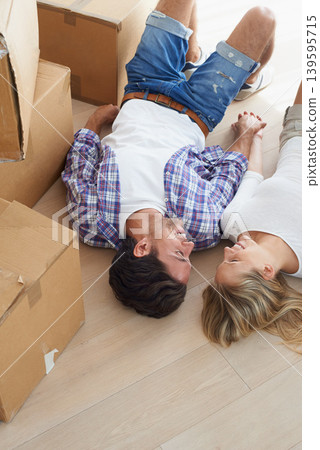 Couple, boxes and happy on floor for real estate, new home or property investment with romance or love. Moving, man and woman with smile or holding hands for fresh start, achievement and dream house Couple, boxes and happy on floor for real estate, new home or property investment with romance or love. Moving, man and woman with smile or holding hands for fresh start, achievement and dream house 139595715