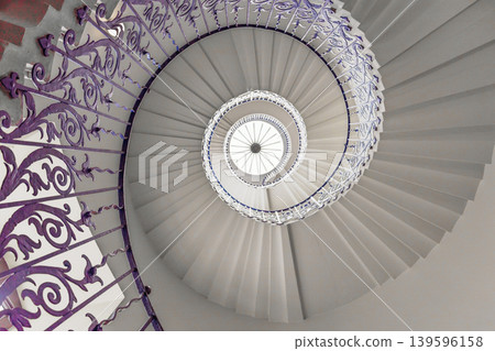 Top down view of an elegant spiral staircase with ornate iron railings Top down view of an elegant spiral staircase with ornate iron railings 139596158