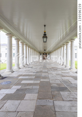 Long empty colonnade with white pillars and stone floor Long empty colonnade with white pillars and stone floor 139596159