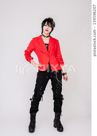 A female model in a red jacket with a rock-inspired style. 139596207