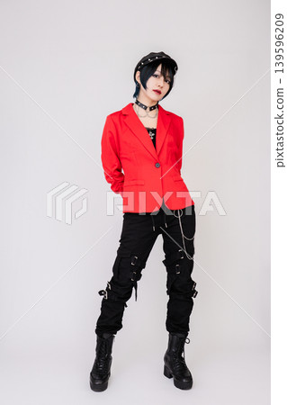 A female model in a red jacket with a rock-inspired style. 139596209