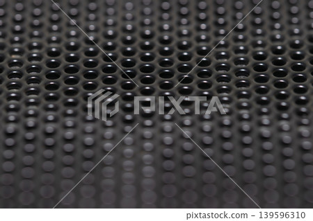 Black perforated metal mesh background with shallow depth of field 139596310