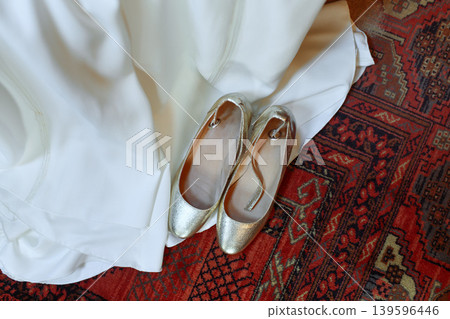 Boho wedding ivory dress and golden shoes on vintage Persian rug 139596446
