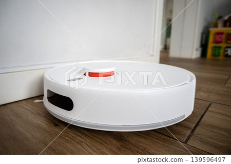 Robot vacuum cleaner cleaning wooden floor 139596497