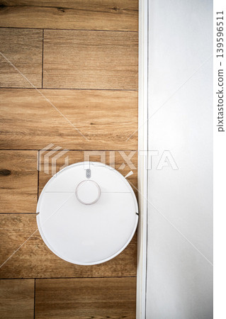 Robot vacuum cleaner cleaning wooden floor 139596511