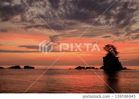 高岡市，恩納岩的輪廓在富山灣中漂浮，以日出的天空為背景。 139596945