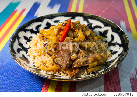 抓飯(Plov),烏茲別克斯坦的傳統菜餚:用羊肉和胡蘿蔔烹製的米飯。 抓飯(Plov),烏茲別克斯坦的傳統菜餚:用羊肉和胡蘿蔔烹製的米飯。 139597012