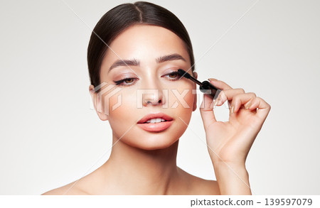 Beauty woman applying black mascara on eyelashes Beauty woman applying black mascara on eyelashes 139597079