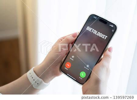 A woman takes an incoming call from a nutritionist. Consultation and support, combating excess weight and eating disorders. Healthy lifestyle guidance and remote healthcare services. A woman takes an incoming call from a nutritionist. Consultation and support, combating excess weight and eating disorders. Healthy lifestyle guidance and remote healthcare services. 139597269