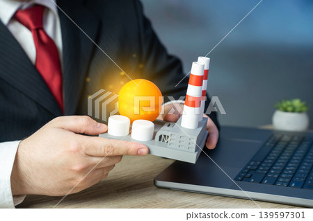 A businessman examines a model of an industrial plant. Chemical plant. Energy facility. Investment in infrastructure construction. Strategic planning for industrial development. A businessman examines a model of an industrial plant. Chemical plant. Energy facility. Investment in infrastructure construction. Strategic planning for industrial development. 139597301