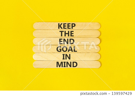 Keep the end goal in mind symbol. Concept words Keep the end goal in mind on beautiful wooden sticks. Beautiful yellow paper background. Business keep the end goal in mind concept. Copy space. Keep the end goal in mind symbol. Concept words Keep the end goal in mind on beautiful wooden sticks. Beautiful yellow paper background. Business keep the end goal in mind concept. Copy space. 139597429