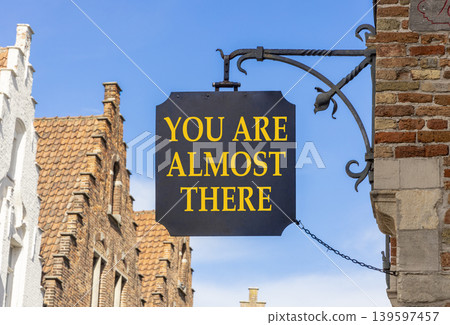 You are almost there symbol. Concept words You are almost there on beautiful black road sign. Beautiful blue sky background. Business You are almost there motivational support concept. Copy space You are almost there symbol. Concept words You are almost there on beautiful black road sign. Beautiful blue sky background. Business You are almost there motivational support concept. Copy space 139597457
