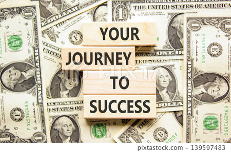 Your journey to success symbol. Concept words Your journey to success on beautiful wooden blocks. Beautiful dollar bills background. Business motivational your journey to success concept. Copy space. Your journey to success symbol. Concept words Your journey to success on beautiful wooden blocks. Beautiful dollar bills background. Business motivational your journey to success concept. Copy space. 139597483