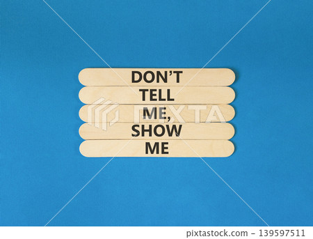 Tell or show symbol. Concept words Do not tell me, show me on beautiful wooden sticks. Beautiful blue paper background. Business tell or show concept. Copy space. Tell or show symbol. Concept words Do not tell me, show me on beautiful wooden sticks. Beautiful blue paper background. Business tell or show concept. Copy space. 139597511