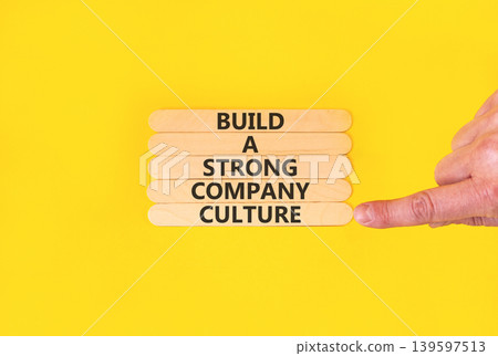 Strong company culture symbol. Concept words Build a strong company culture on beautiful wooden sticks. Beautiful yellow paper background. Business strong company culture concept. Copy space. 139597513
