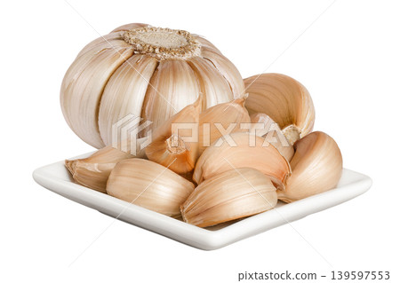 garlic cloves in ceramic bowl isolated on white background close up 139597553