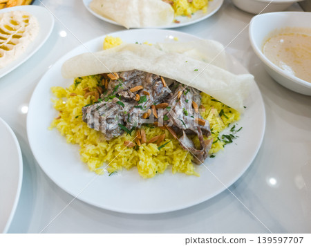 Traditional Jordanian Mansaf with Lamb and Yellow Rice on White Plate Traditional Jordanian Mansaf with Lamb and Yellow Rice on White Plate 139597707