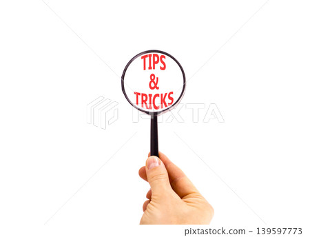 Tips and tricks words symbol. Concept words Tips and tricks on beautiful magnifying glass. Beautiful white background. Businessman hand. Business tips tricks motivational support concept. Copy space. Tips and tricks words symbol. Concept words Tips and tricks on beautiful magnifying glass. Beautiful white background. Businessman hand. Business tips tricks motivational support concept. Copy space. 139597773