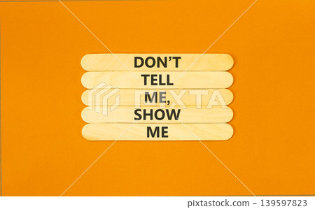 Tell or show symbol. Concept words Do not tell me, show me on beautiful wooden sticks. Beautiful orange paper background. Business tell or show concept. Copy space. 139597823