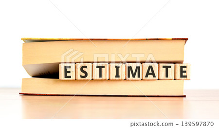 Estimate word symbol. Concept word Estimate on beautiful wooden blocks in beautiful book. Beautiful wooden table white background. Business support help estimate word concept. Copy space. Estimate word symbol. Concept word Estimate on beautiful wooden blocks in beautiful book. Beautiful wooden table white background. Business support help estimate word concept. Copy space. 139597870