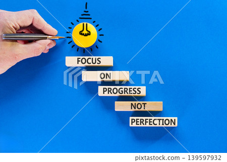 Progress or perfection words symbol. Concept words Focus on progress not perfection on beautiful wooden blocks. Beautiful blue paper background. Business progress or perfection concept. Copy space. Progress or perfection words symbol. Concept words Focus on progress not perfection on beautiful wooden blocks. Beautiful blue paper background. Business progress or perfection concept. Copy space. 139597932