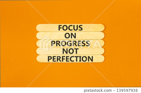 Progress or perfection words symbol. Concept words Focus on progress not perfection on beautiful wooden sticks. Beautiful orange paper background. Business progress or perfection concept. Copy space. Progress or perfection words symbol. Concept words Focus on progress not perfection on beautiful wooden sticks. Beautiful orange paper background. Business progress or perfection concept. Copy space. 139597938